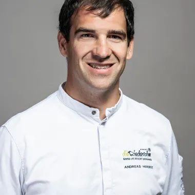 Man in white chef jacket with Good Life Resort Riedlalm logo and embroidered name Andreas Herbst